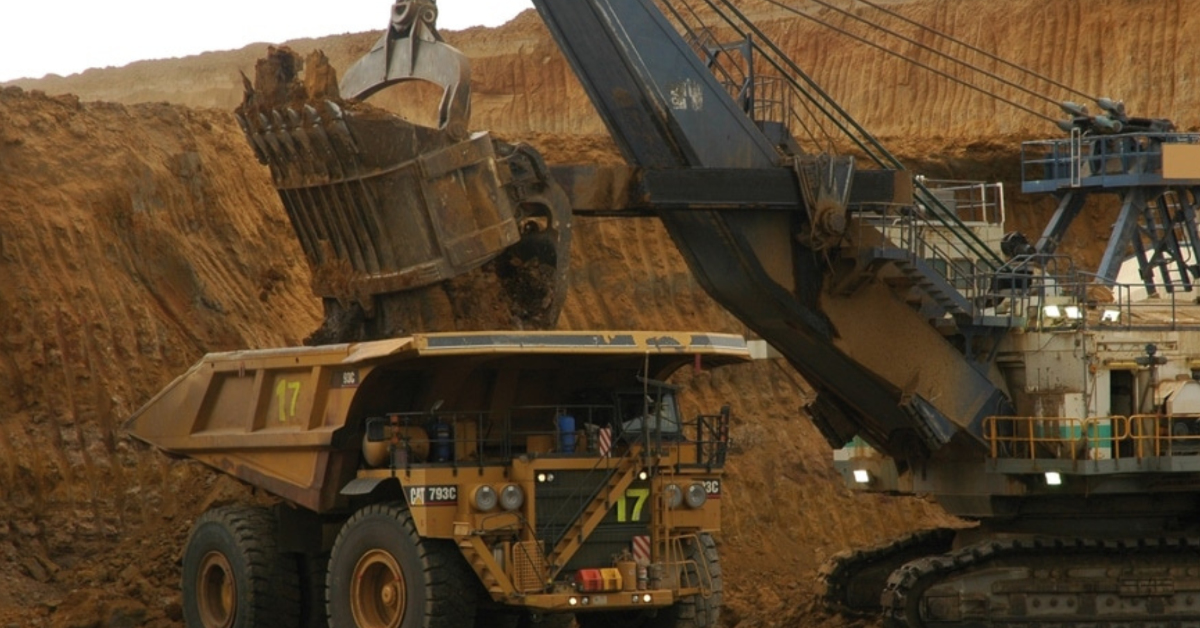 Excavator loading dirt into a mining truck at a coal mine site, representing mining environments covered in the Standard 11 Combined Induction.