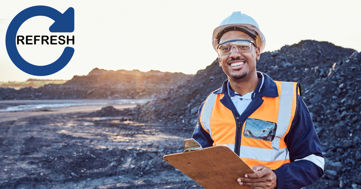 Worker in safety gear holding a clipboard in a mining environment, representing the Standard 11 Surface Mining Induction Refresher.